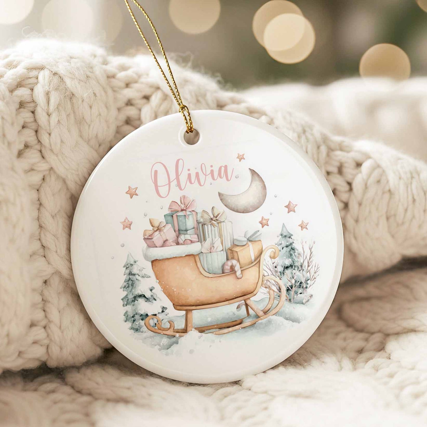Ornement de Noël en céramique avec traîneau aquarelle rempli de cadeaux, lune et étoiles, et prénom personnalisé Olivia