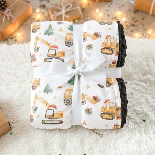 Couverture pour bébé motif camions de construction de Noël, emballée avec un ruban blanc, minky noir doux, idée cadeau festive