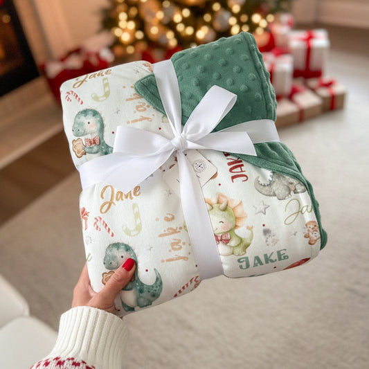 Couverture personnalisée pour bébé avec dinosaures de Noël en aquarelle, prénom imprimé, minky vert doux et ruban cadeau — idée cadeau parfaite pour les fêtes, personnalisée shower de bébé - idée cadeau de Noël pour bébé